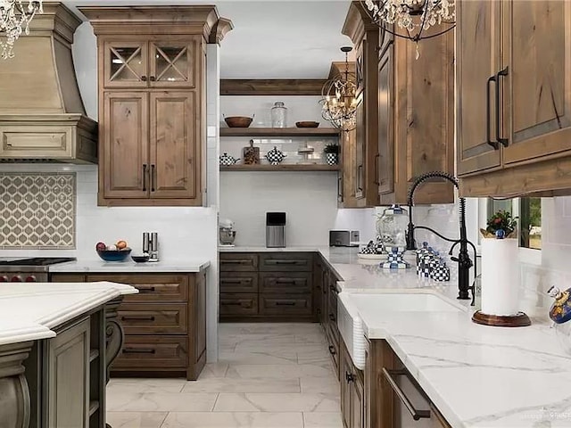 kitchen with marble finish floor, custom exhaust hood, open shelves, stainless steel gas stovetop, and light stone countertops