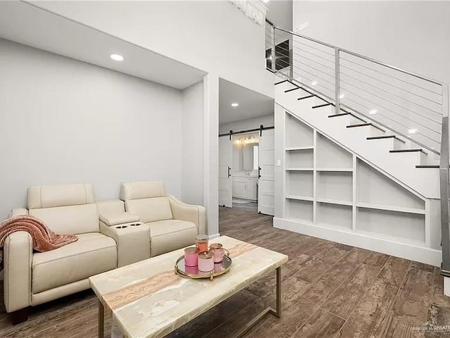 living room with recessed lighting, dark wood-style flooring, stairway, and a barn door