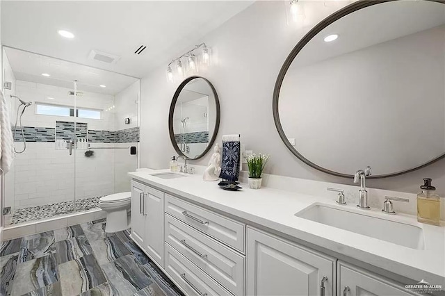 bathroom with double vanity, a sink, toilet, and a shower stall