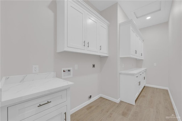 clothes washing area featuring cabinet space, baseboards, light wood-style floors, washer hookup, and electric dryer hookup