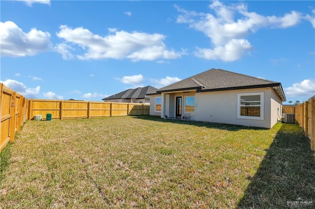 rear view of property with cooling unit, a fenced backyard, a yard, and stucco siding