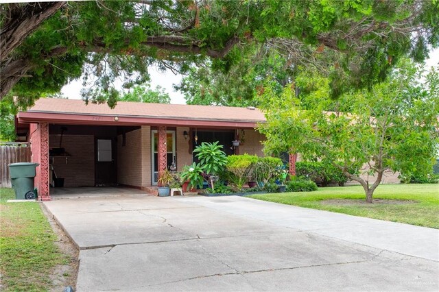 2401 E Austin Ave, Harlingen, TX 78550 - ranch-style house featuring concrete driveway, a front yard, an attached carport, and brick siding