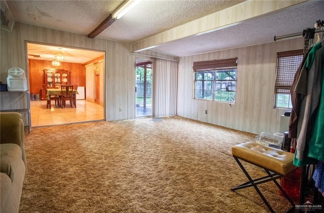 2401 E Austin Ave, Harlingen, TX 78550 - carpeted living area with a textured ceiling, wooden walls, and a chandelier
