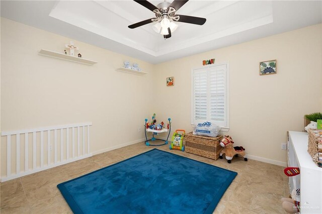 recreation room featuring ceiling fan and a tray ceiling