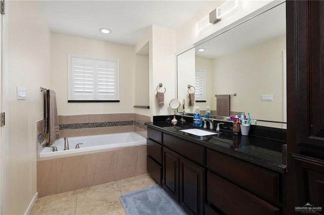 bathroom featuring vanity, tile patterned floors, and tiled tub