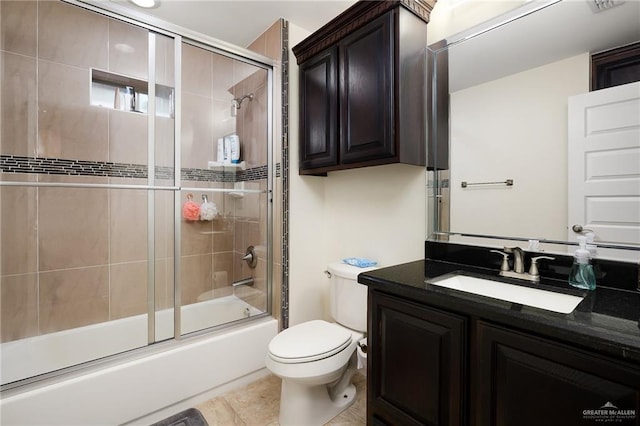 full bathroom featuring tile patterned floors, vanity, toilet, and bath / shower combo with glass door