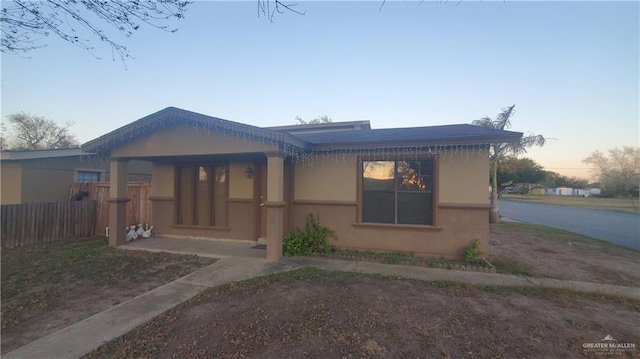 view of front facade featuring fence and stucco siding