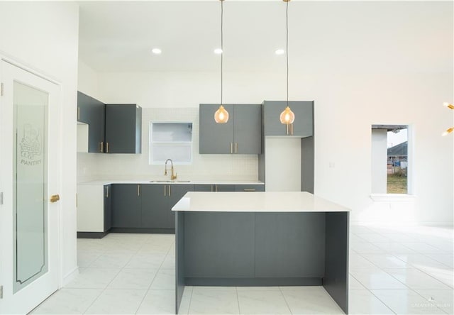 kitchen with gray cabinetry, sink, hanging light fixtures, tasteful backsplash, and light tile patterned flooring