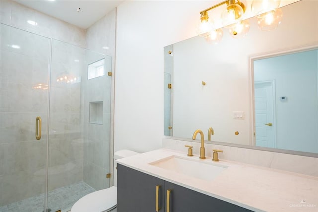 bathroom featuring vanity, toilet, and a shower with shower door