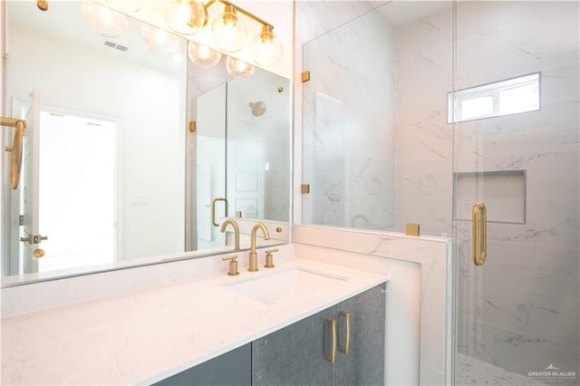 bathroom featuring a shower with door and vanity