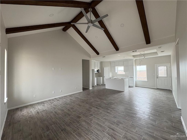 unfurnished living room with beam ceiling, baseboards, dark wood-type flooring, and a ceiling fan