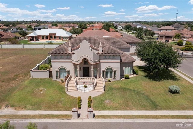 view of front facade with stucco siding, a residential view, fence, and a tiled roof