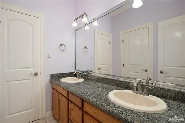 bathroom featuring double vanity, a sink, and tile patterned floors