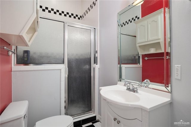 bathroom featuring a stall shower, vanity, and toilet