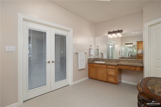 bathroom with tile patterned flooring, french doors, vanity, and baseboards