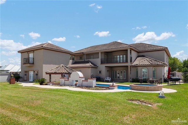 back of property featuring a lawn and a balcony