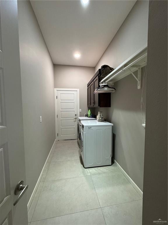 laundry area with cabinets, washer and clothes dryer, and light tile patterned flooring