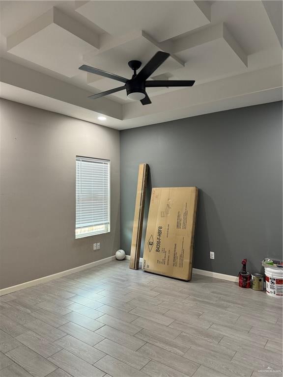 interior space featuring ceiling fan, a tray ceiling, and light hardwood / wood-style flooring