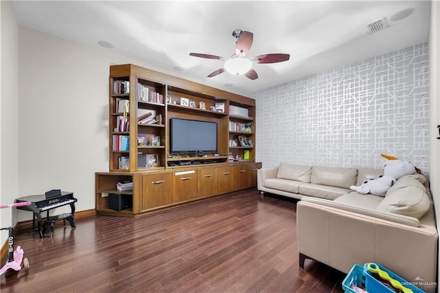 living room featuring ceiling fan, visible vents, dark wood finished floors, and baseboards