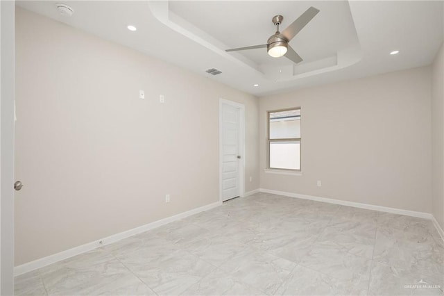 unfurnished room featuring a tray ceiling and ceiling fan