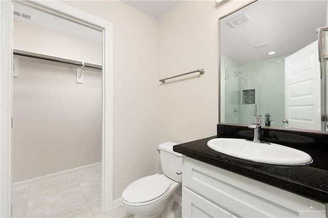 bathroom featuring vanity, a shower with door, and toilet