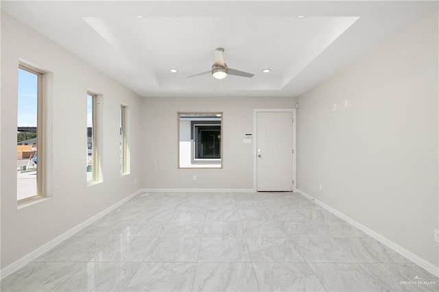 unfurnished room featuring a tray ceiling and ceiling fan