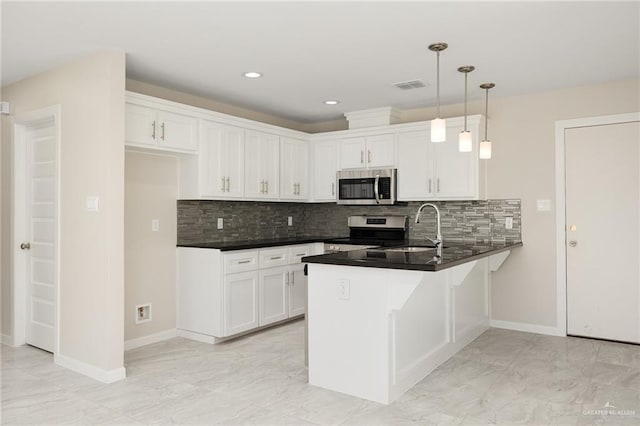 kitchen featuring sink, white cabinetry, stainless steel appliances, decorative light fixtures, and kitchen peninsula