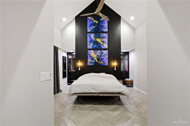 bedroom with light parquet flooring and high vaulted ceiling