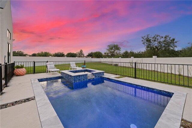 pool at dusk with an in ground hot tub