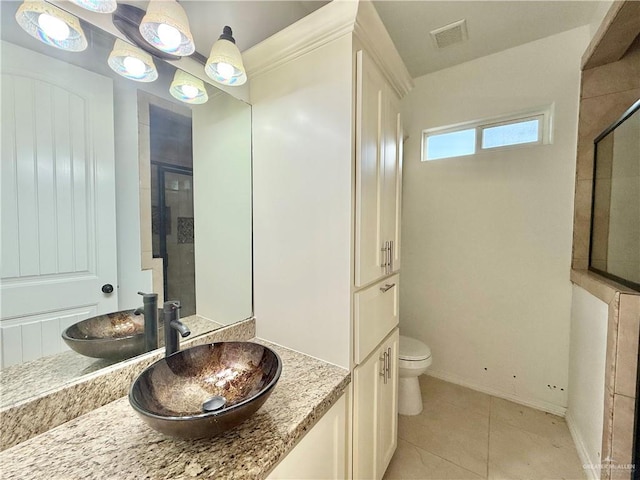 bathroom featuring visible vents, toilet, a tile shower, vanity, and tile patterned floors