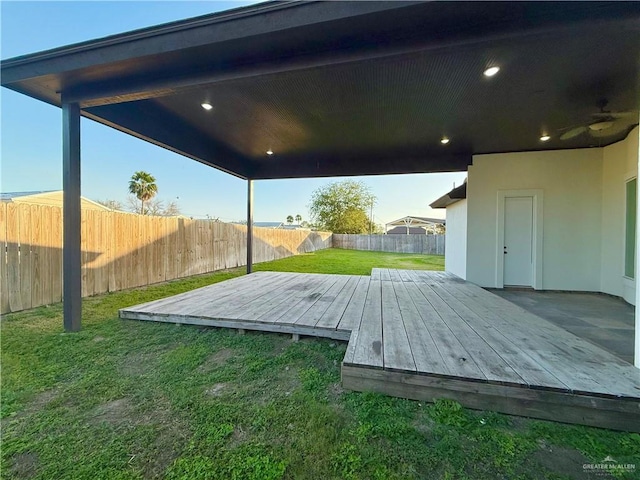 wooden deck with a fenced backyard and a lawn