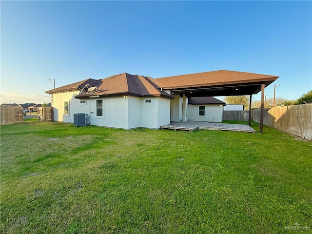 rear view of house featuring a fenced backyard, a yard, and central AC unit