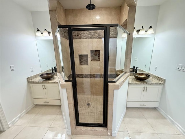 full bath with a shower stall, two vanities, and a sink