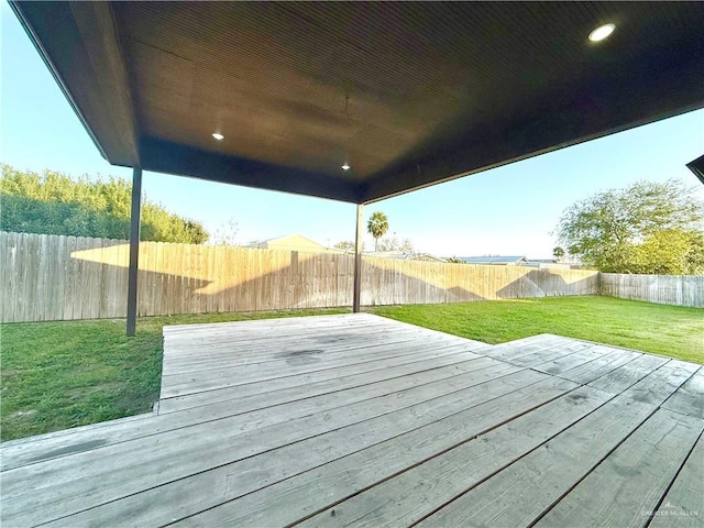 wooden terrace featuring a fenced backyard and a yard