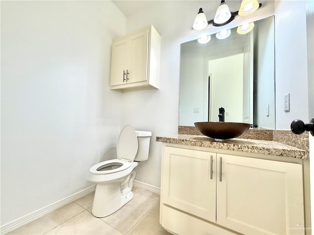 bathroom with toilet, tile patterned flooring, baseboards, and vanity