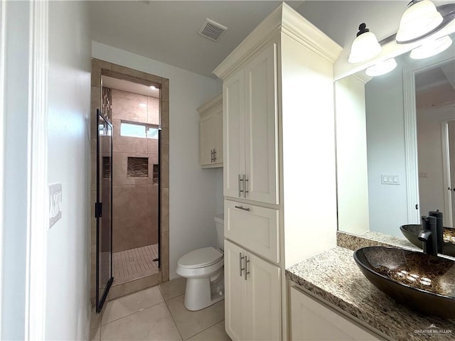 full bath with toilet, vanity, visible vents, tile patterned floors, and a stall shower