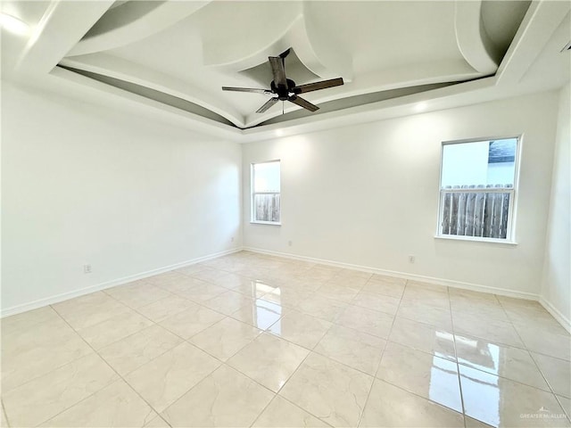 unfurnished room featuring baseboards, a tray ceiling, and a ceiling fan