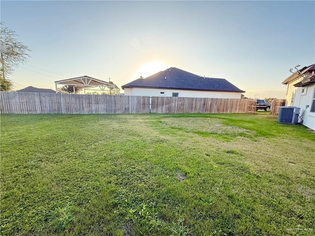 view of yard featuring fence and central AC unit