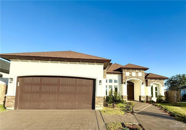 view of front of house with stone siding, concrete driveway, an attached garage, and stucco siding