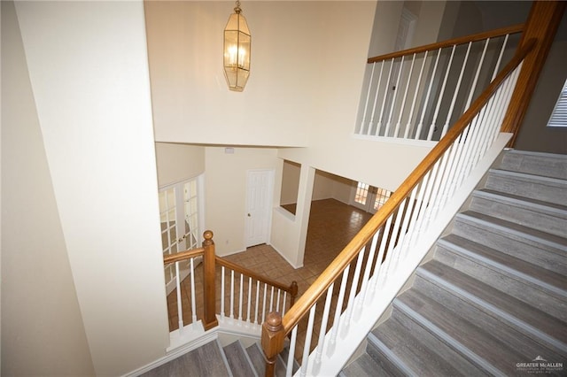 staircase featuring hardwood / wood-style floors and an inviting chandelier