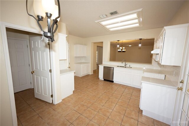 kitchen with kitchen peninsula, sink, decorative light fixtures, dishwasher, and white cabinetry