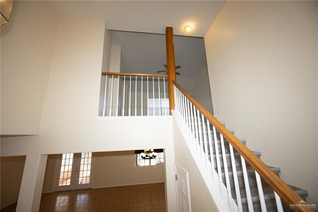 staircase featuring ceiling fan and high vaulted ceiling