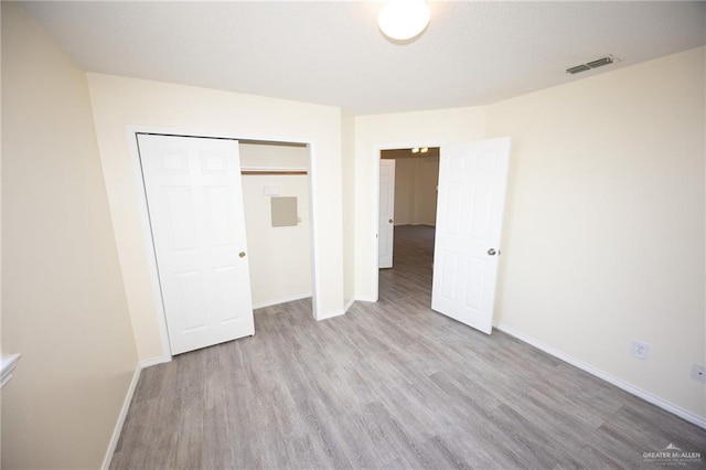 unfurnished bedroom with a closet and light hardwood / wood-style flooring