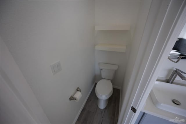 bathroom featuring hardwood / wood-style floors, toilet, and sink