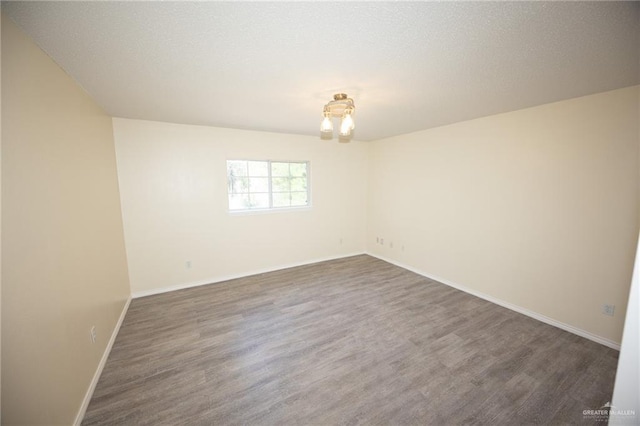 unfurnished room featuring dark hardwood / wood-style floors and a chandelier