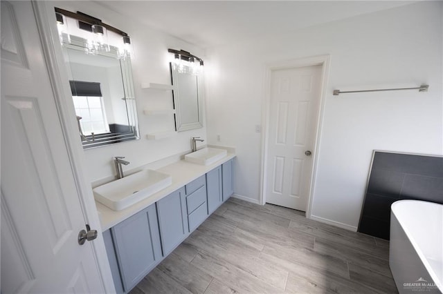 bathroom with hardwood / wood-style floors, vanity, and a bath