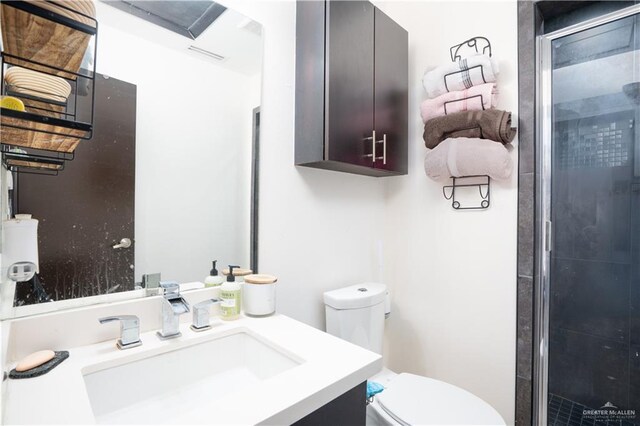full bath featuring toilet, vanity, and a shower stall