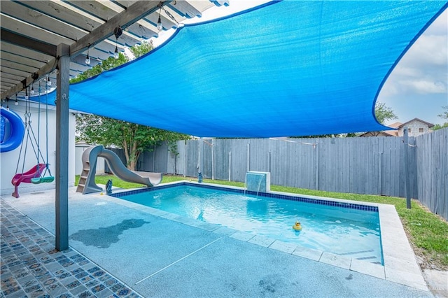 view of swimming pool with a water slide, a fenced backyard, and a patio area