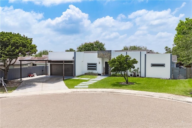 contemporary house with an attached garage, driveway, stucco siding, and a carport