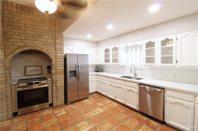 2115 Ichabod Ln, Edinburg, TX 78539 - kitchen featuring appliances with stainless steel finishes, tasteful backsplash, glass insert cabinets, white cabinets, and light countertops